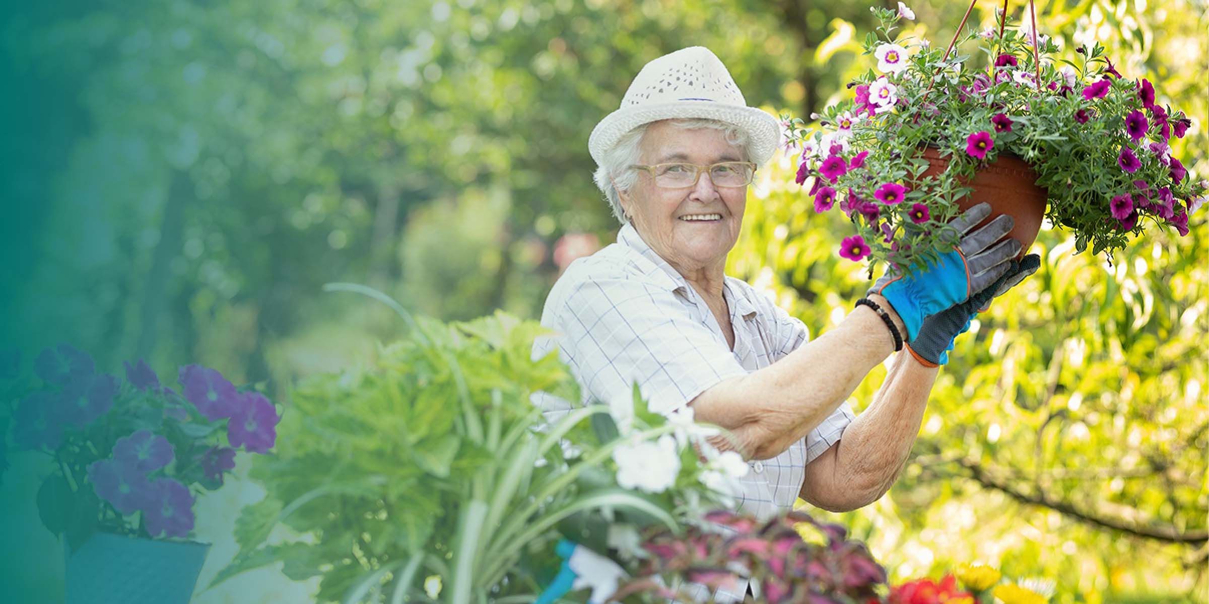 Seniorin mit Hut bei der Gartenarbeit in Blumengarten