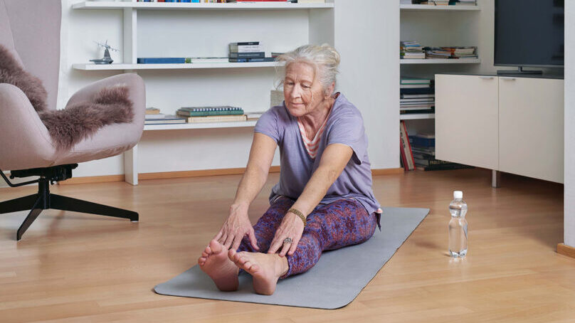 Seniorin trainiert zu Hause mit dem online Yoga-Kurs von Pro Senectute Kanton Zürich