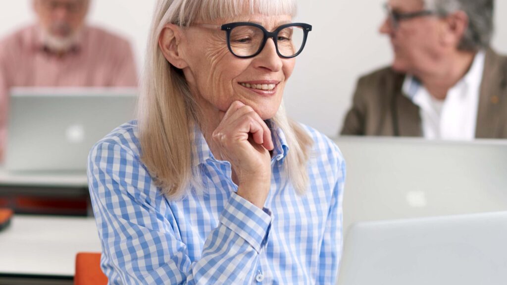 Seniorin mit Brille vor dem Laptop